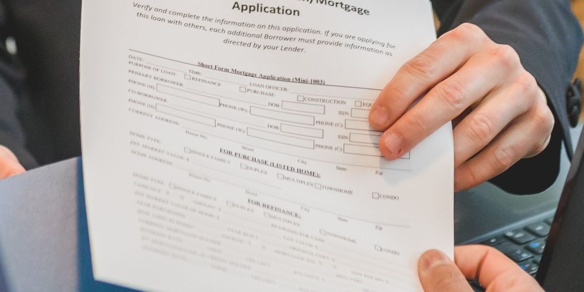 An individual meticulously reviewing financial documents for a mortgage pre-approval for a significant purchase.